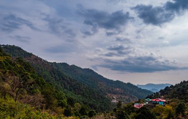 Arka planda vadi ve bulutlu gökyüzü, doğa ve güzellik konsepti olan dramatik dağlar.