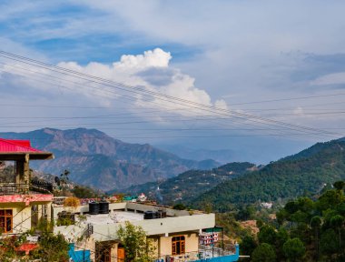Dağlı evlerin yüksek açılı çekimleri ve arka planda bulutlu gökyüzü, güzellik konsepti