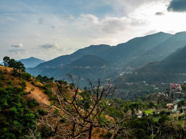  Arkasında bulutlu gökyüzü ve binaları olan güzel vadinin manzarası.