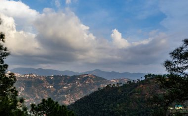  bulutlu mavi gökyüzünün altında evleri ve terasları olan dağların fotoğrafları.