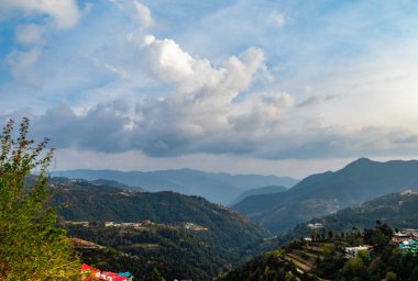 Arka planda bulutlu mavi gökyüzü ve tepeleri olan harika bir teras tipi ekin alanı.