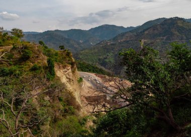 Yol trafiği ve bulutlu gökyüzü aydınlık güneşli bir günde geniş tepeler, doğa konsepti.