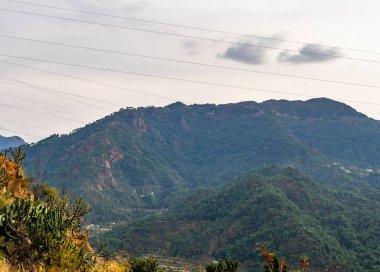 Geniş bir dağ manzarası ve arka planda parlak gökyüzü, doğal konsept.