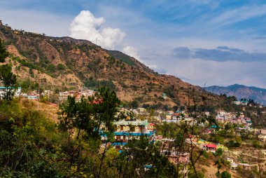 Kasaba ve bulutlu gökyüzü ile geniş dağlar, doğa konsepti.