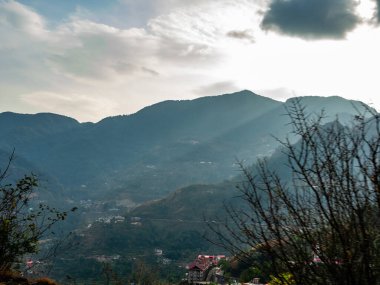 Dağların geniş manzarası ve arka planda bulutlu gökyüzü, doğal konsept.