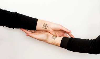 Kişisel verileri okuyan iki el bir qr kodu ile birbirlerini tutarlar.