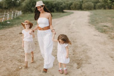 İki kızı olan annem yaz günü köyde beyaz elbiseler içinde, çiftlikte yaşıyor.