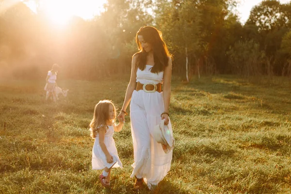 Familie moeder met kinderen staan bij zonsondergang op een zomerdag op de boerderij — Stockfoto