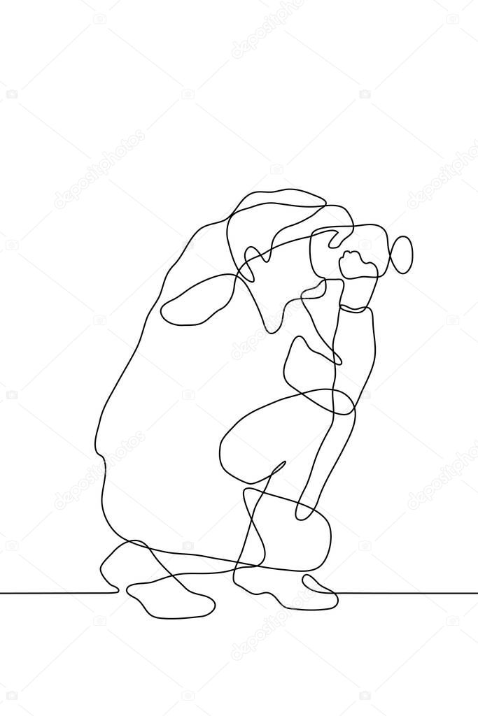 linear drawing of the profile of a seated man with a camera with which he takes something off-screen. Continuous line drawing of a black outline of a journalist or photographer at work. For animation