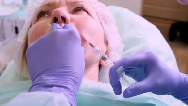 Schönheitschirurgie, der Arzt macht einen Schuss ins Gesicht — Stockvideo