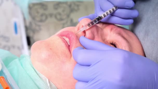 Пластическая хирургия, доктор делает укол в лицо — стоковое видео