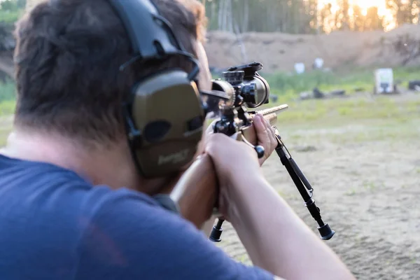 Чоловік в окулярах з бородою тримає снайперську гвинтівку — стокове фото