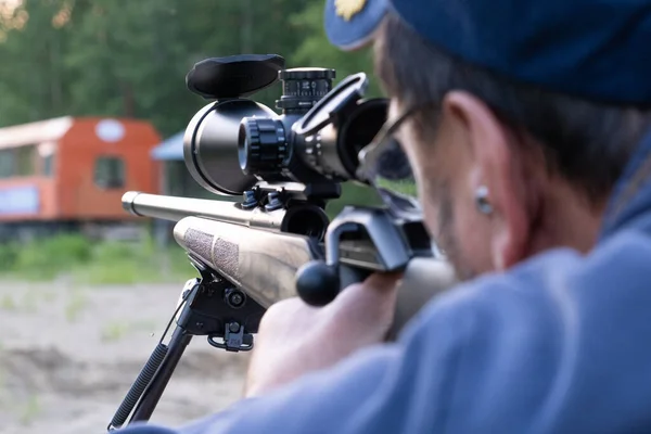 Un homme à lunettes avec une barbe tient un fusil de sniper — Photo