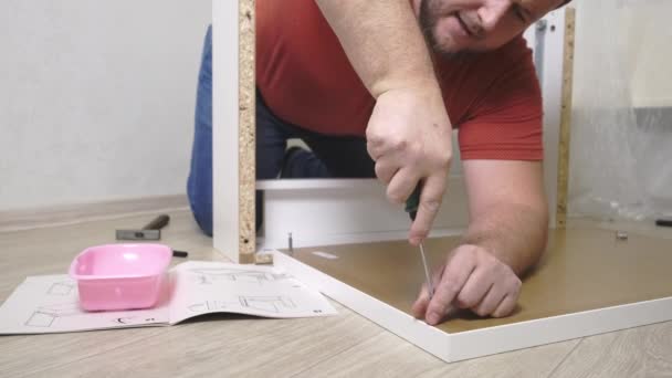 Man collects boxes from chipboard with a screwdriver — 비디오