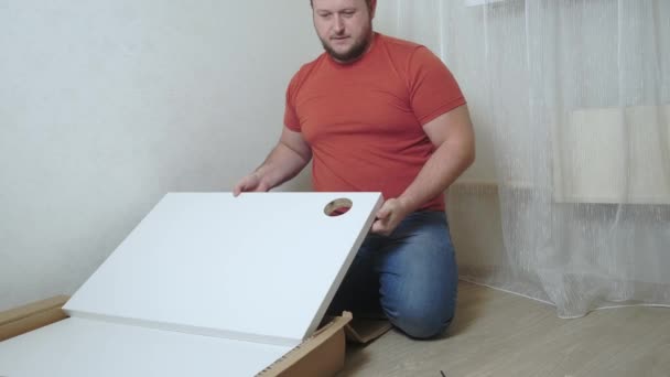 Чоловік збирає коробки з ДСП з викруткою — стокове відео