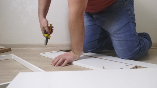 Man collects boxes from chipboard with a screwdriver — 비디오