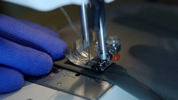 Close-up of sewing machine needle rapidly moves up and down.