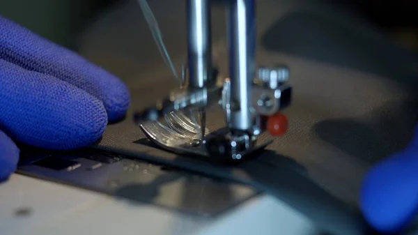 Primer plano de la aguja de la máquina de coser se mueve rápidamente hacia arriba y hacia abajo. Imagen De Stock