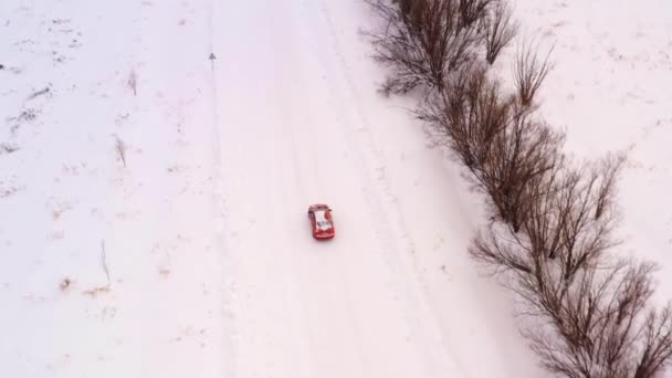 Paseos en coche en un camino nevado de invierno, vista superior . — Vídeo de stock