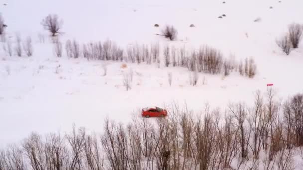 Car rides on a winter snowy road, top view. — ストック動画