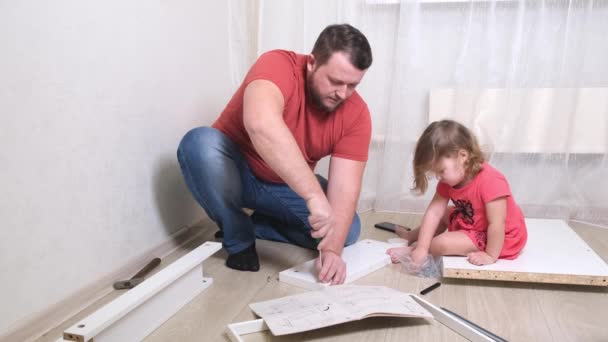 Pa en dochter verzamelen samen meubels in de woonkamer van het huis. Dochter zal papa helpen.. — Stockvideo