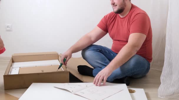 Mann sammelt mit Schraubenzieher Kisten aus Spanplatten — Stockvideo