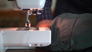 Dikiş makinesi iğnesinin yakın çekimi hızla yukarı ve aşağı hareket eder. 