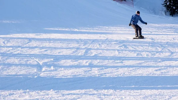 Snowboardista jezdí na horském svahu v zimním dni — Stock fotografie