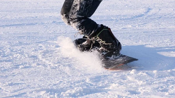 Snowboardåkare hoppa på en snowboard, närbild, snowboardåkare fötter — Stockfoto