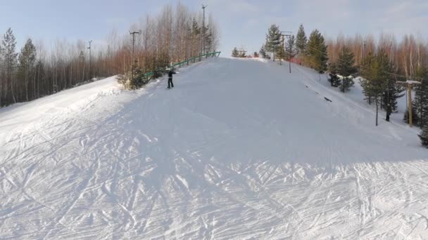 Snowboarder πέφτει σε μια βουνοπλαγιά σε μια χειμωνιάτικη μέρα, top view — Αρχείο Βίντεο