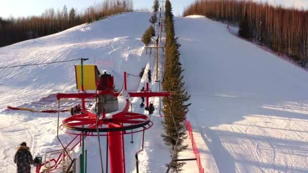 丘の中腹にチェアリフト冬の日に山の中腹にスキーリフト. — ストック動画