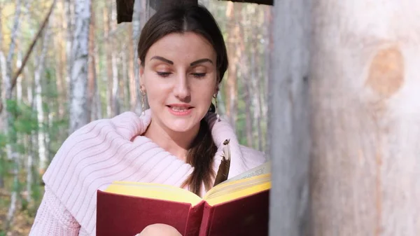 Ευτυχισμένο ελκυστικό χαμογελαστή γυναίκα γράφει ποίηση με φτερό στο δάσος της άνοιξης. — Φωτογραφία Αρχείου