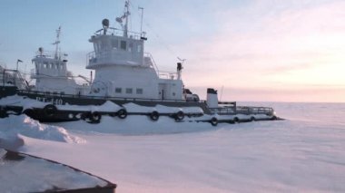 The ship froze in the ice of the river.