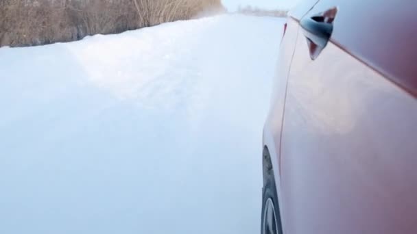 Vista de la rueda trasera de un coche deportivo sedán en movimiento en invierno — Vídeo de stock