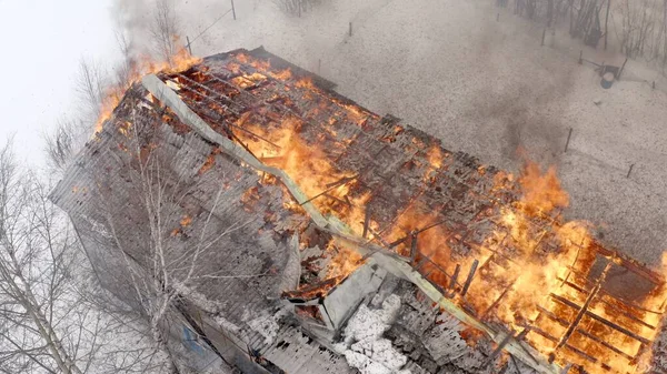 Aerial view the burning roof of the building in winter.