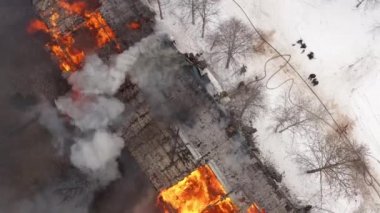 Aerial view the burning roof of the building in winter.