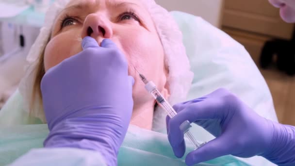 Plastic surgery, the doctor makes a shot in the face — Stock Video