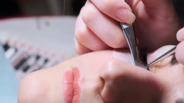 Kleben künstliche Wimpern auf die Frau. Kosmetischer Eingriff — Stockvideo