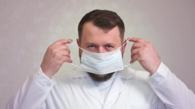 Beyaz önlüklü, maske takan bir doktorun rahat portresi..