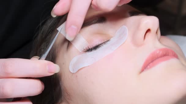 Attaccando ciglia artificiali alla donna. Procedura cosmetica — Video Stock