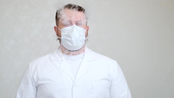 Doctor in medical mask from which comes the smoke — Stock Video