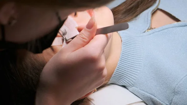 Coller des cils artificiels à la femme. Procédure cosmétique — Photo