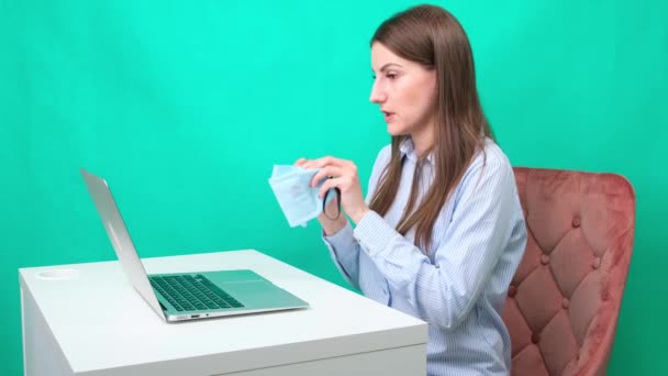 Una mujer joven dice en línea en las redes sociales cómo usar máscaras médicas protectoras , — Vídeo de stock