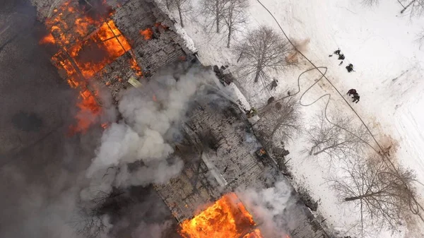 Aerial view the burning roof of the building in winter.