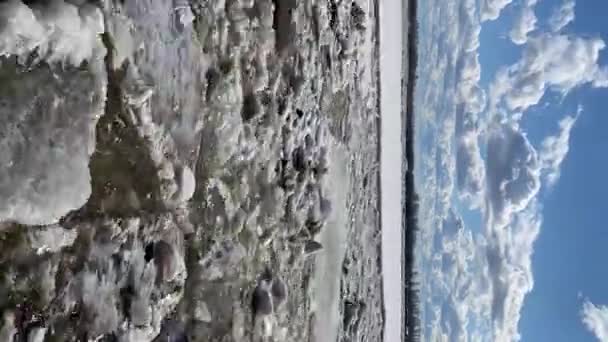 Verticale tijdspanne van de rivier waarop het ijs smolt, en de wolken in een blauwe lucht lopen in de tegenovergestelde richting — Stockvideo