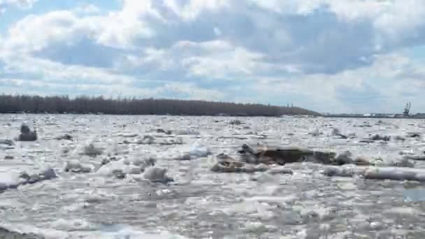 Время прохождения реки, на которой растаял лед, и облака в голубом небе бегут в противоположном направлении — стоковое видео