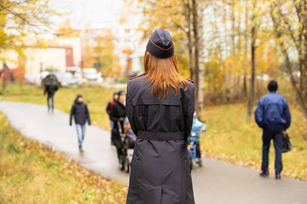 Politi kvinde står med ryggen i sort uniform Royaltyfrie stock-billeder