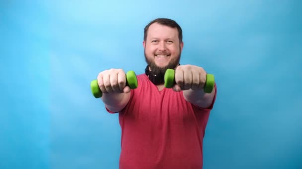 Thick bearded nice bodybuilder in pink T-shirt with very small dumbbells is very tense doing exercises — Stock Video