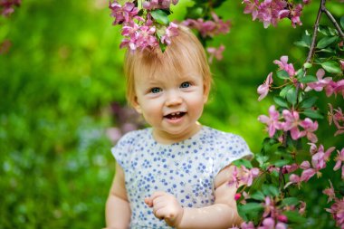 Parkta, kiraz çiçeği dalının yanında tatlı bir kız.