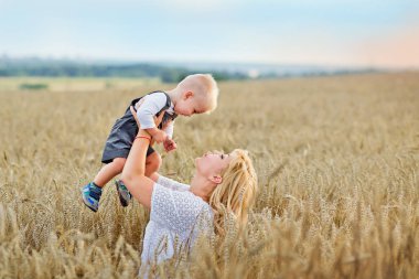 Anne oğlunu bir buğday tarlasında kollarına aldı.